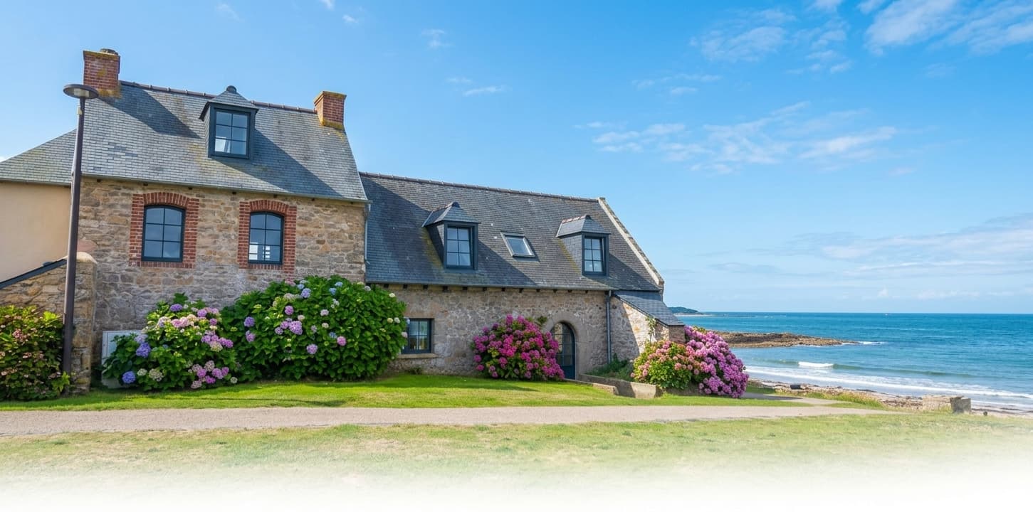 Longère bretonne en pierre aux fenêtres posées par Finestra, bordée d'hortensias